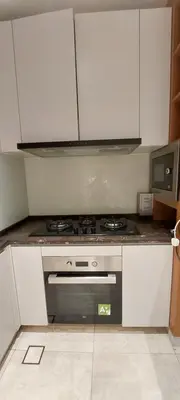 a kitchen with a stove and white cabinets at Anggun Platinum Suites in Kuala Lumpur