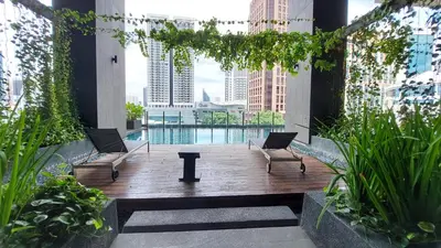 a patio with two chairs and a pool in a building at Anggun Platinum Suites in Kuala Lumpur