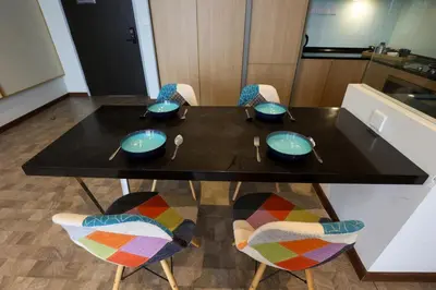 a black table with four chairs and blue bowls on it at ExpressionZ Suites KLCC by EC in Kuala Lumpur