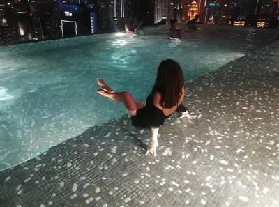 a young girl in a swimming pool at night at Expressionz Professional Suites by AURORA SUMMER SUITES in Kuala Lumpur