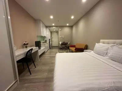 a hotel room with a large bed and a kitchen at One Bukit Ceylon by Home Suites in Kuala Lumpur