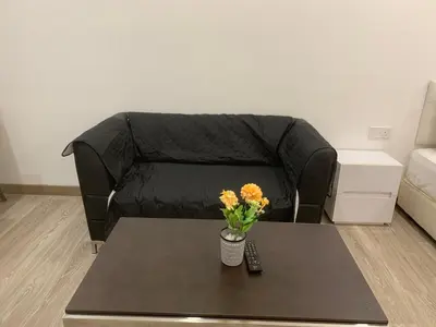 a living room with a couch and a table with flowers at RS Suites In Bukit Bintang in Kuala Lumpur