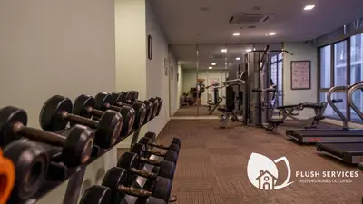a gym with dumbbells and weights in a room at Fairlane Residences by Plush in Kuala Lumpur