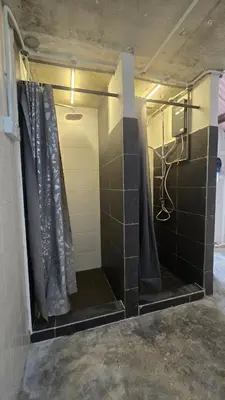 a bathroom with a shower with black tiled walls at The Manor by Mingle - Poolside Access Next Door in Kuala Lumpur