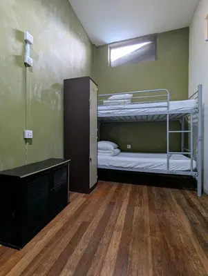 a room with two bunk beds and a wooden floor at The Manor by Mingle - Poolside Access Next Door in Kuala Lumpur