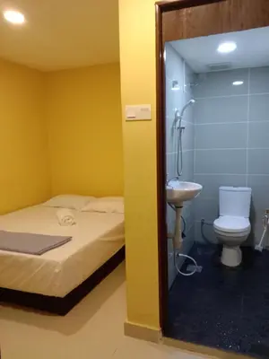 a bathroom with a shower and a bed and a sink at RAS International Hotel in Kuala Lumpur