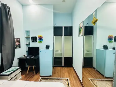 a room with a desk and a refrigerator at Taragon Homestay - Kuala Lumpur, Malaysia in Kuala Lumpur