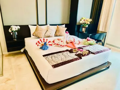 a large white bed in a room with flowers on it at Tropicana The Residence KLCC By Rainbow Suites in Kuala Lumpur