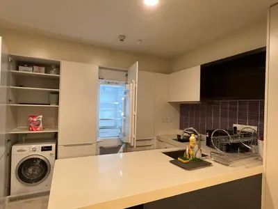 a kitchen with a sink and a washing machine at Tropicana The Residence KLCC By Rainbow Suites in Kuala Lumpur