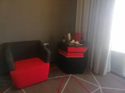 a red chair and a table in a room at The RED in Kuala Lumpur