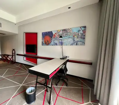 a room with a desk with a lamp on it at The RED in Kuala Lumpur