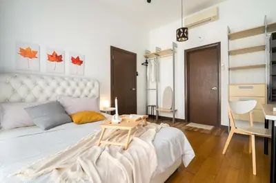 a bedroom with a bed with a table and a desk at NaiBnB in Regalia Residence in Kuala Lumpur