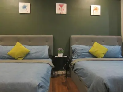 two beds with yellow and blue pillows in a room at Fahrenheit 88 Suites Bukit Bintang H 3R in Kuala Lumpur