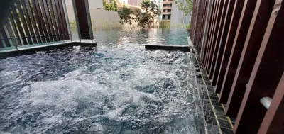a pool of water in a building with a fence at Lucentia Lalaport BBCC, Stuning Infinity Pool in Kuala Lumpur