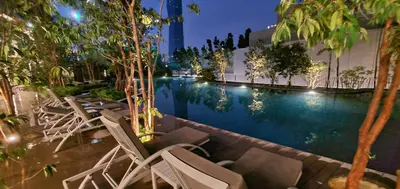 a pool at night with chairs and trees at Lucentia Lalaport BBCC, Stuning Infinity Pool in Kuala Lumpur