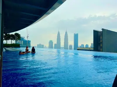 two people sitting in a infinity pool on a building at Eaton suites KLCC at KL in Kuala Lumpur