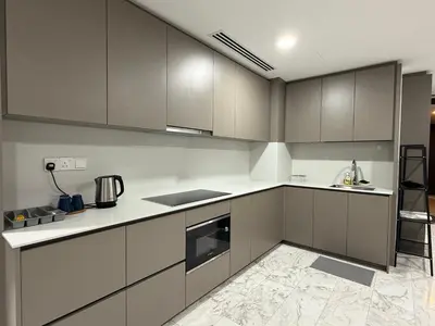 a kitchen with gray cabinets and white counters at Eaton suites KLCC at KL in Kuala Lumpur