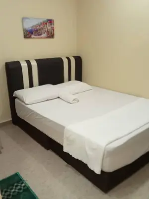 a bed with a black and white bed frame in a room at RAS Hotel in Kuala Lumpur