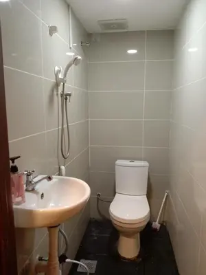 a bathroom with a toilet and a sink at RAS Hotel in Kuala Lumpur