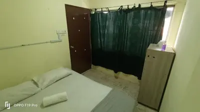 a small bedroom with a bed and a shower at RAS Hotel in Kuala Lumpur