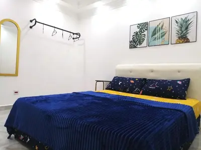 a bedroom with a bed with a blue and yellow blanket at Apartment Low Cost 2 Bilik Asnor Homestay KL in Kuala Lumpur