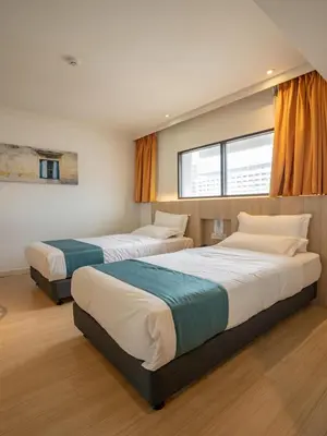 a bedroom with two beds and a window at Floresta Hotel Chinatown in Kuala Lumpur