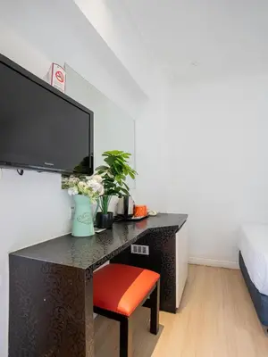 a bedroom with a desk with a tv and a chair at Floresta Hotel Chinatown in Kuala Lumpur