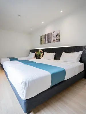a large bed in a room with two beds at Floresta Hotel Chinatown in Kuala Lumpur