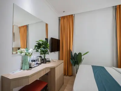 a bedroom with a bed and a desk with a mirror at Floresta Hotel Chinatown in Kuala Lumpur