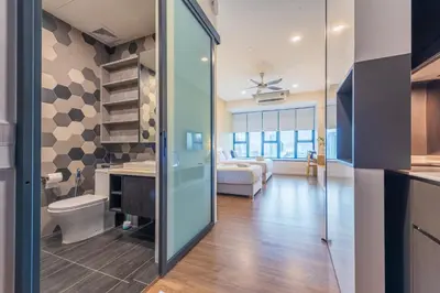 a bathroom with a toilet and a bed in a room at KLCC SkyTowerViewSuite AT CeylonzSuites in Kuala Lumpur