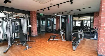 a gym with several exercise equipment in a brick building at KLCC SkyTowerViewSuite AT CeylonzSuites in Kuala Lumpur