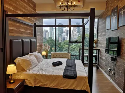 a bedroom with a bed with a large window at Romantic Log Cabin - walk to KL Tower, KLCC, Bukit Bintang in Kuala Lumpur