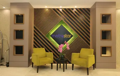 a lobby with two chairs and a sign on a wall at Metrostar Hotel Kuala Lumpur in Kuala Lumpur