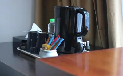 a counter top with a coffee maker and utensils at Metrostar Hotel Kuala Lumpur in Kuala Lumpur