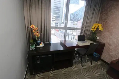 a desk in a room with a large window at Metrostar Hotel Kuala Lumpur in Kuala Lumpur