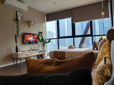 a living room with two beds and a tv at Scarletz Suites KLCC by De Harlequins Guesthouse in Kuala Lumpur