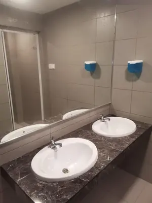 a bathroom with two sinks in front of a mirror at SCC Hotel Chinatown in Kuala Lumpur