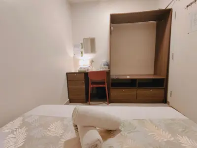 a bedroom with a bed with a dresser and a desk at SCC Hotel Chinatown in Kuala Lumpur