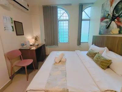 a large white bed in a room with a desk at SCC Hotel Chinatown in Kuala Lumpur