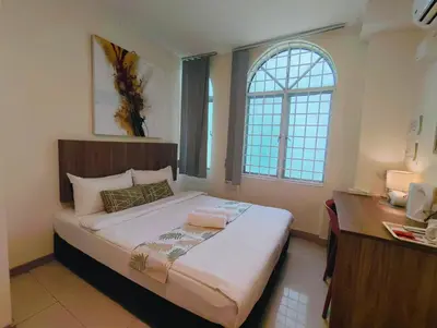 a bedroom with a bed and a desk and a window at SCC Hotel Chinatown in Kuala Lumpur