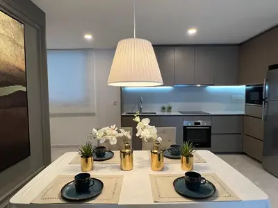 a kitchen with a table with black and gold appliances at Eaton Residences KLCC by WSD in Kuala Lumpur