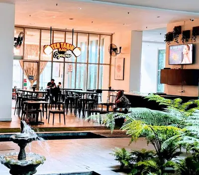 a restaurant with tables and chairs and people sitting at tables at Regalia Modern Studio in Kuala Lumpur