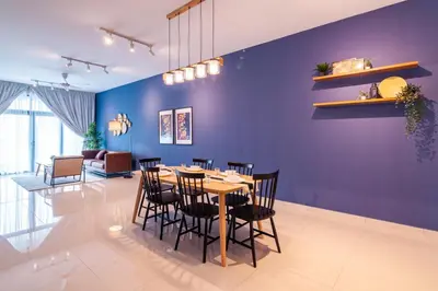 a dining room with a blue wall and a table and chairs at Legasi @ Kampung Bharu in Kuala Lumpur