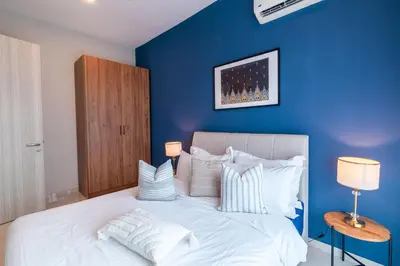a blue bedroom with a large bed with white pillows at Legasi @ Kampung Bharu in Kuala Lumpur
