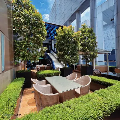 a patio with a table and chairs and trees at The Platinum KLCC by Veedu Hauz in Kuala Lumpur