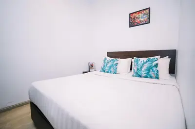 a bedroom with a large white bed with blue pillows at Swing & Pillows - Dataran Merdeka Kuala Lumpur in Kuala Lumpur