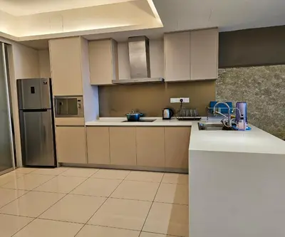 a kitchen with white cabinets and a refrigerator at The Wisdom Apartment in Kuala Lumpur