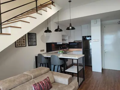 a living room and kitchen with a table and a couch at ARTE Mont Kiara Host By HOST CORNER SUITES in Kuala Lumpur