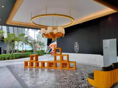 a living room with a table and chairs and a chandelier at ARTE Mont Kiara Host By HOST CORNER SUITES in Kuala Lumpur