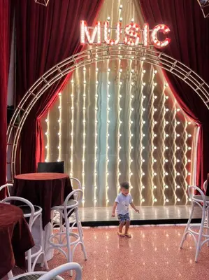 a little boy standing in front of a mitzory stage at Luxury Scarletz Suite KLCC in Kuala Lumpur